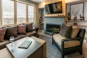 a living room with a couch and a fireplace at Okemo Mountain Lodging by Vail Resorts in Ludlow
