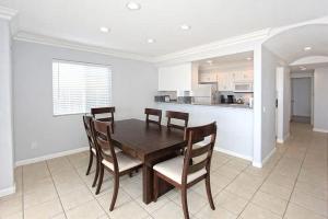 a dining room with a wooden table and chairs at 8-Bedroom Beachfront Triplex – Ideal for Extended apts in Newport Beach