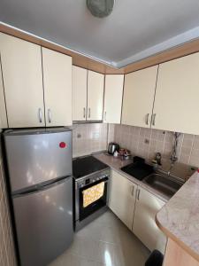 a kitchen with white cabinets and a stainless steel refrigerator at ANKA apartman in Smederevo