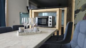 a table with two wine glasses and a microwave at Totall Panoramic Studio in Moreni