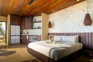 a bedroom with a large bed and a kitchen at Casa Riverstone in Dominical