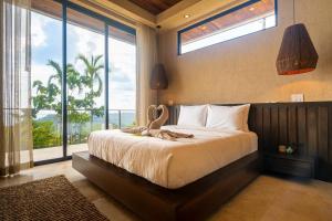 a bedroom with a bed with a large window at Casa Riverstone in Dominical +41 photos