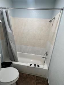 a bathroom with a toilet and a bath tub with a toilet at Hwy 59 Motel Laredo Medical Center in Laredo