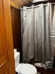 a bathroom with a toilet and a shower curtain at Sailor Setubal in Setúbal