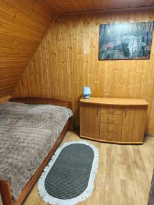 a bedroom with a bed and a wooden wall at Domki Całoroczne Pod Lasem in Łobozew +16 photos