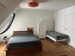 a bedroom with a bed and a small bed and a window at Appartements des Halles - Chambres d'Hôtes in Savenay