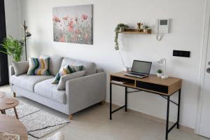 a living room with a couch and a desk with a laptop at Casa Anna - Velapi - Los Alcázares in San Javier