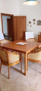 a wooden dining room table with chairs and a table at Casa con veranda a 10 min dal mare in Lizzano +23 photos