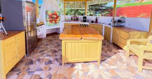 a kitchen with a large yellow island in the middle at Pousada Chateau Bella Vista in Campos do Jordão