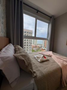 a bedroom with a bed with a large window at Infinity 1302 - Piscina, Academia e Praia a Poucos Passos in Vila Velha +22 photos