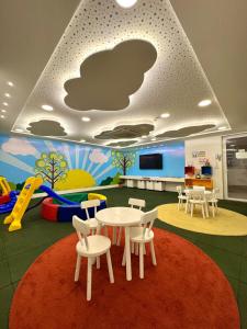 a classroom with a table and chairs and a play area at Infinity 1302 - Piscina, Academia e Praia a Poucos Passos in Vila Velha
