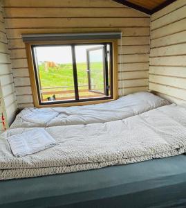 a large bed in a room with a window at Vestra-Fíflholt cabin 1 in Hvolsvöllur