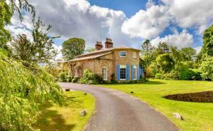 an old house with a road in front of it at Unique Manor House PLUS Jacuzzi PLUS BBQ Cabin in Maybole