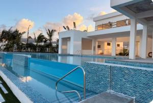 a villa with a swimming pool in front of a house at Villa Elegance-3 min Walk to the Beach-20 mins to Ochi Rios in Richmond