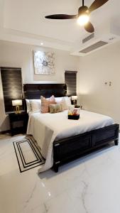a bedroom with a large bed and two lamps at Villa Elegance-3 min Walk to the Beach-20 mins to Ochi Rios in Richmond +45 photos