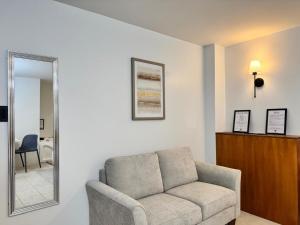 ein Wohnzimmer mit Sofa und Spiegel in der Unterkunft Hotel Bombay in Baños