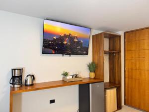 ein Fernseher, der in einem Zimmer an der Wand hängt in der Unterkunft Hotel Bombay in Baños