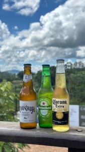 three bottles of beer sitting on a railing at Estância da Mata in CÃ¡ssia
