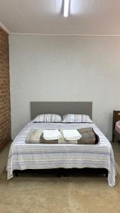 a bed in a room with two towels on it at Estância da Mata in CÃ¡ssia