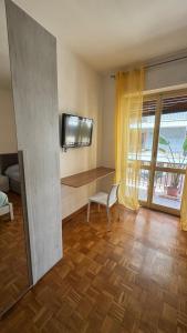 a living room with a desk and a tv on the wall at Bartolo Health and Wellness in Cagliari