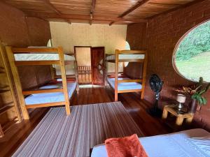 a room with three bunk beds and a window at Wisdom Forest Lodge in Tena