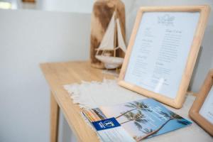 a table with a book and a sail boat on it at The Shell Shack on Whisper Bay in Cannonvale
