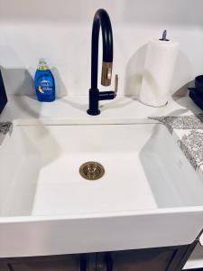 a white kitchen sink with a black faucet at Just Peace Homes in Moncton +24 photos