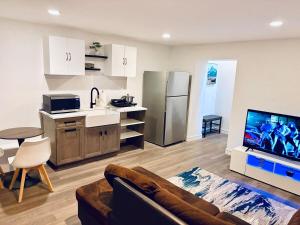 a kitchen and living room with a couch and a tv at Just Peace Homes in Moncton