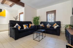 a living room with a black couch and a table at Hauzify I La Caseta in Santa Cristina d'Aro