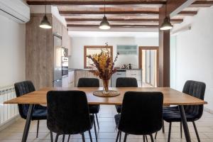 a kitchen and dining room with a wooden table and chairs at Hauzify I La Caseta in Santa Cristina d'Aro