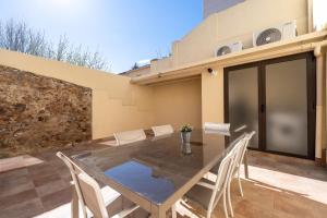 a patio with a table and chairs and a building at Hauzify I La Caseta in Santa Cristina d'Aro