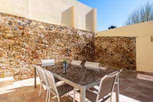 a dining room with a stone wall and a table and chairs at Hauzify I La Caseta in Santa Cristina d'Aro +10 photos