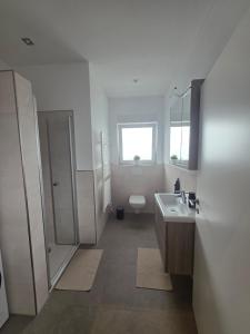 a white bathroom with a sink and a toilet at SchwalbenNest Pfeifers OdenwaldNest in Rimbach +19 photos