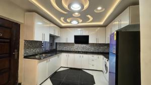 a kitchen with white cabinets and a ceiling at Duswin Hotel Gloucester, Freetown, SL in Freetown