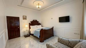 a bedroom with a bed and a flat screen tv at Duswin Hotel Gloucester, Freetown, SL in Freetown