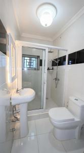 a bathroom with a toilet and a sink and a shower at Duswin Hotel Gloucester, Freetown, SL in Freetown +24 photos