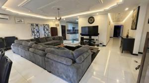 a living room with a couch and a television at Duswin Hotel Gloucester, Freetown, SL in Freetown
