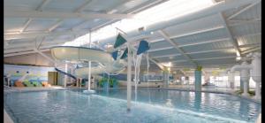 a indoor swimming pool with a water slide at 3 bedroom, 2 bathroom caravan Presthaven Beach Resort in Talacre