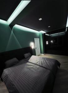 a bedroom with a bed with a green wall at Central Residence Sky Apartment in Rădăuţi +9 photos