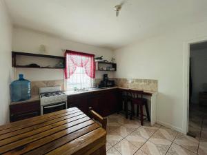 a kitchen with a table and a stove and a window at Windy days Apartments in Utila +5 photos