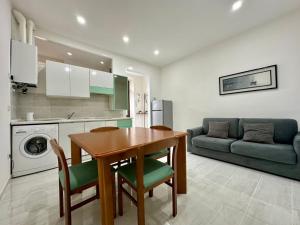 a kitchen and living room with a table and a couch at Verso il Lago in Laveno-Mombello