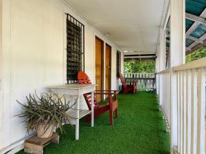 a porch with green grass and a table and chairs at Windy days Apartments in Utila