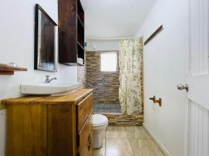 a bathroom with a sink and a toilet at Windy days Apartments in Utila