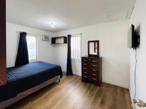 a bedroom with a bed and a dresser and a mirror at Windy days Apartments in Utila