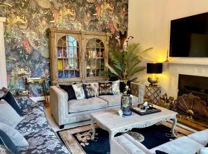 a living room with a couch and a table at Unique Manor House PLUS Jacuzzi PLUS BBQ Cabin in Maybole +36 photos