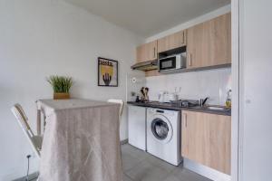 a small kitchen with a washing machine and a washer at Ô Bon Vivre - Vidéo-projecteur, Wifi, Netflix inclut, Terrasse in Toulouse +6 photos