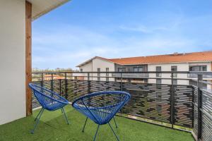 two blue chairs sitting on a balcony at Ô Bon Vivre - Vidéo-projecteur, Wifi, Netflix inclut, Terrasse in Toulouse
