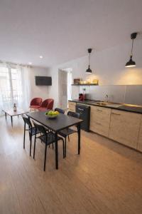 a living room with a table and chairs and a kitchen at 31CaL QuEROL Boutique centre Puigcerdà in Puigcerdà