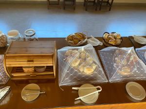 a table with bags of bread and baskets on it at Pousada Vila Serrana in Serra Negra
