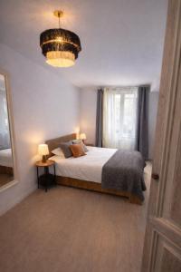 a bedroom with a large bed and a chandelier at 31CaL QuEROL Boutique centre Puigcerdà in Puigcerdà
